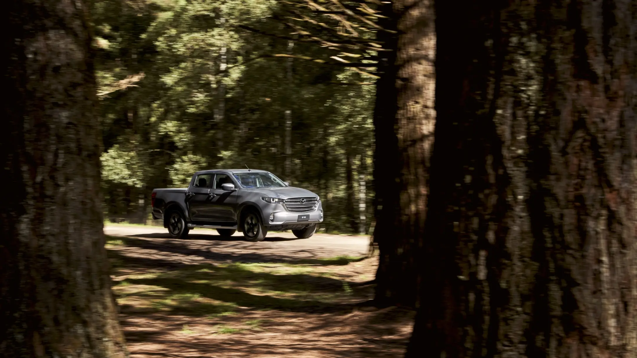 Camioneta Mazda BT-50 gris en el bosque