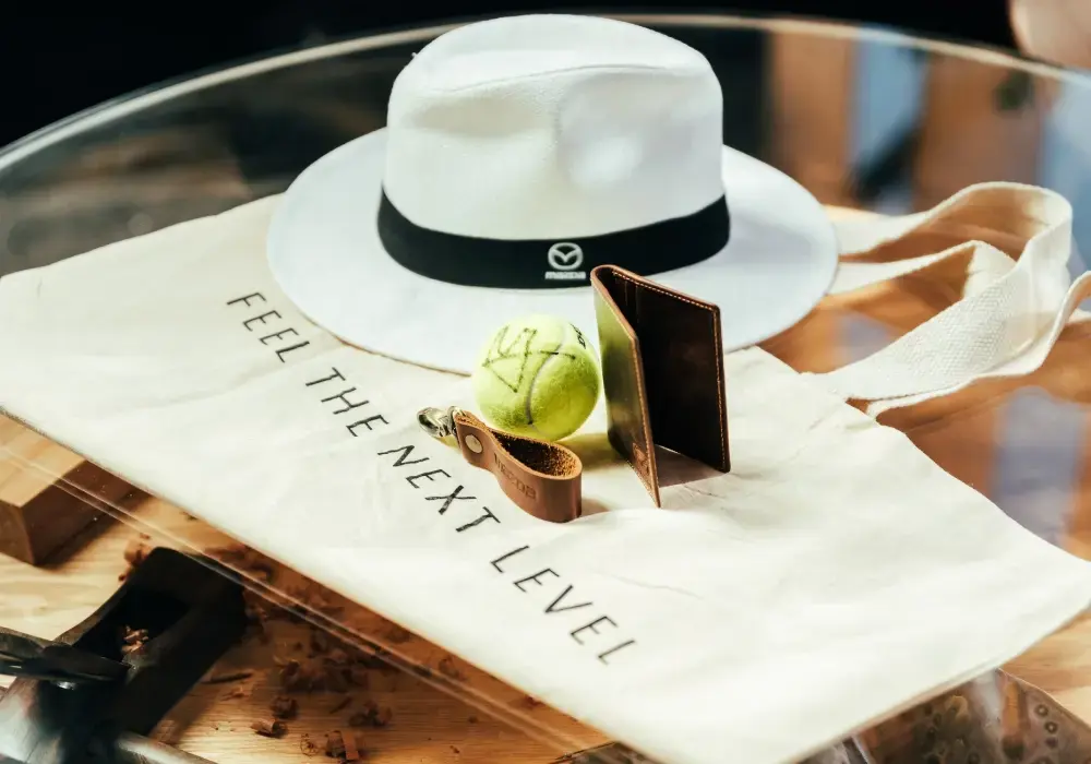 Sombrero, bolsa, pelota de tenis y accesorios de cuero de la marca Mazda.