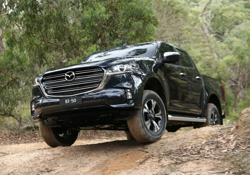 Camioneta doble cabina Mazda BT-50 4x4 en un camino de ripio en condiciones difíciles.