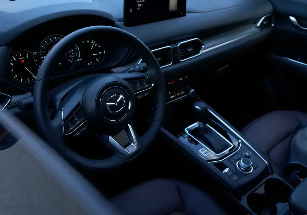 Primer plano del sistema Mazda Connect en funcionamiento con Apple CarPlay o Android Auto activo (mapa + música visible).
