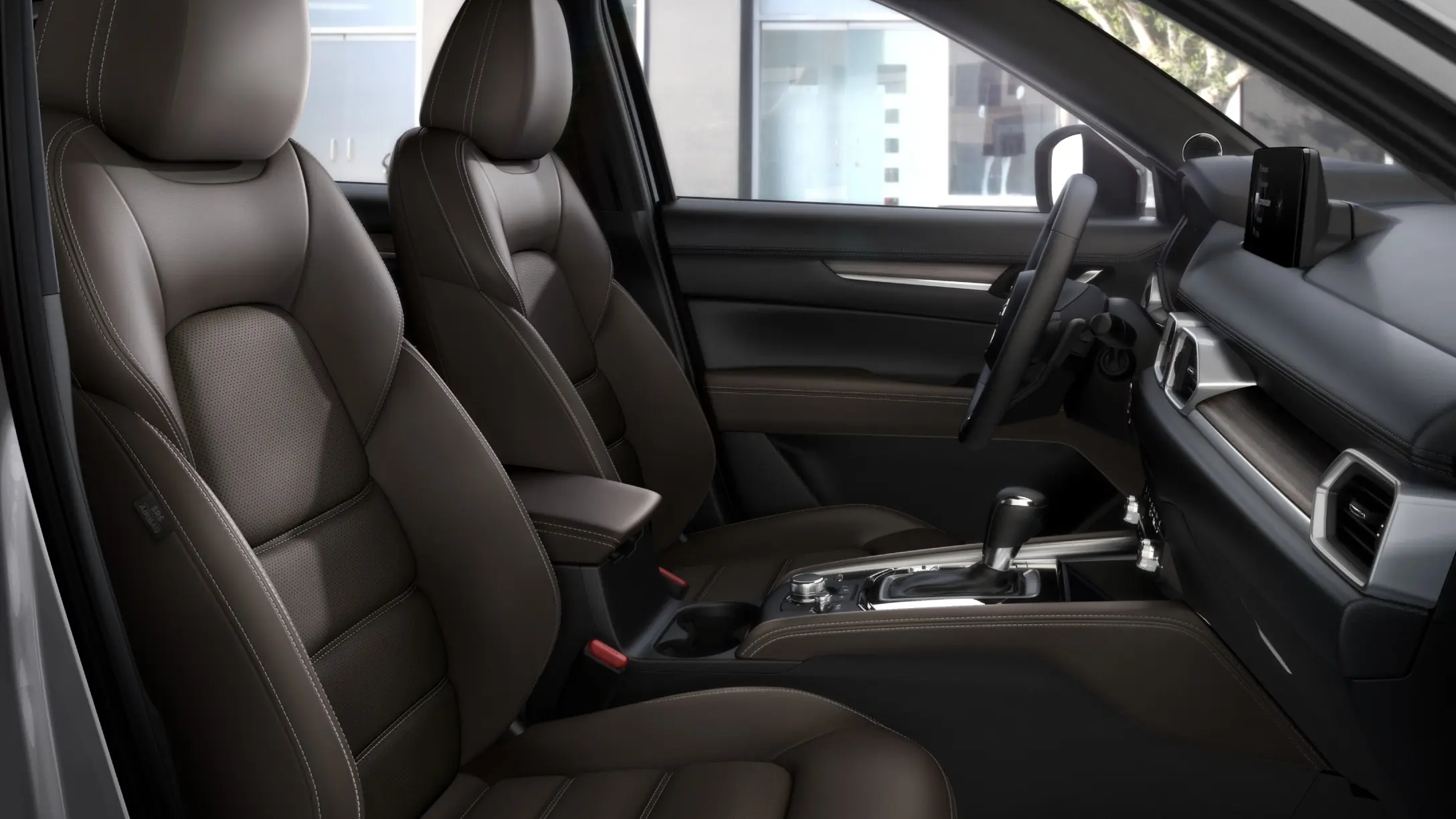 Interior del Mazda CX-5, mostrando asientos de cuero marrón y un diseño elegante.