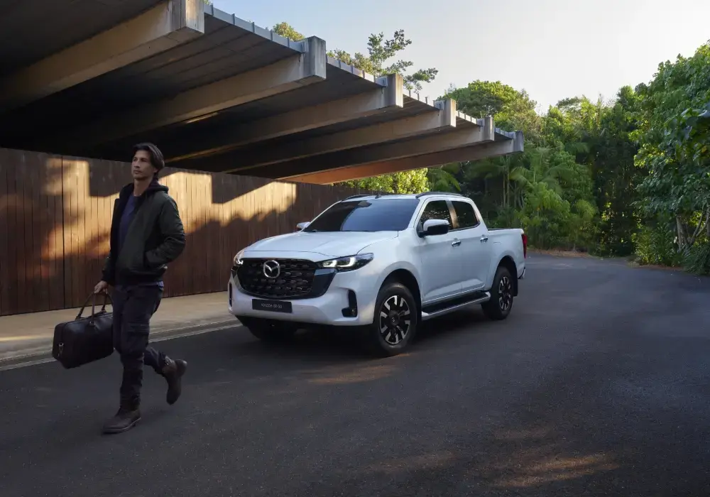 Camioneta aventura transitando por un camino de montaña con paisaje natural de fondo.